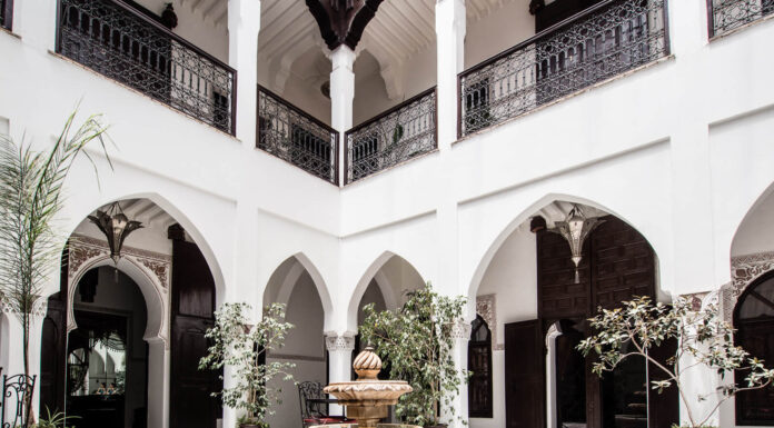 Traditional Moroccan riad courtyard with tiled fountain and lush garden